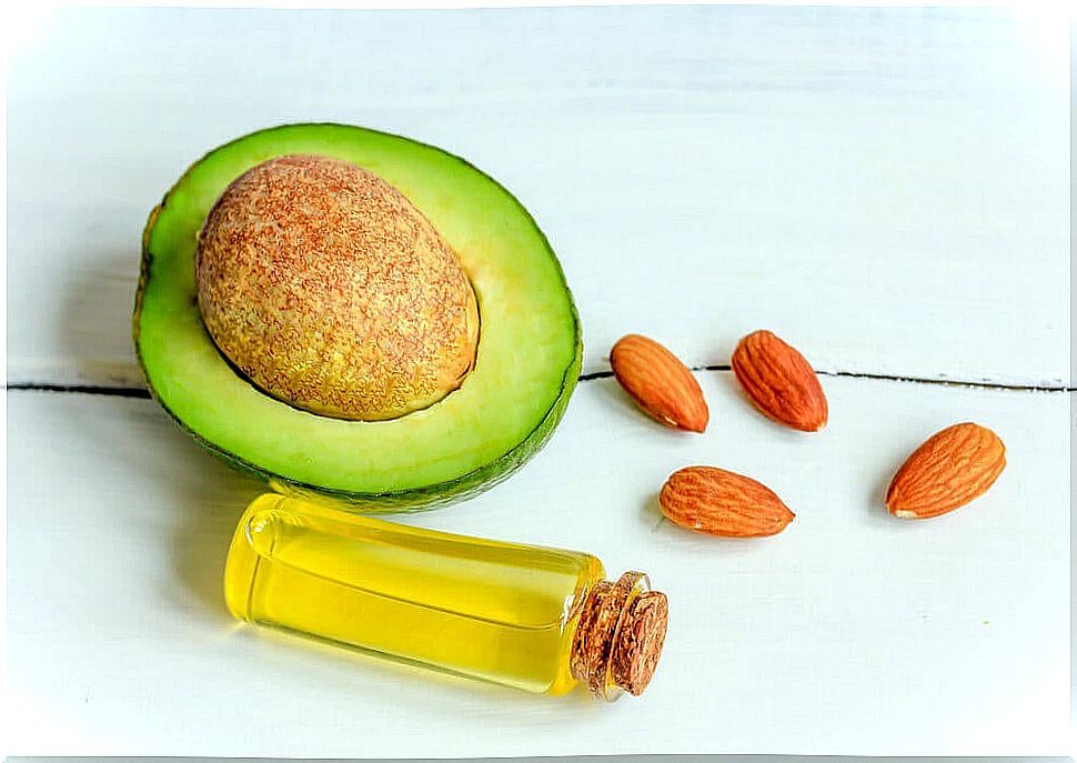 Half an avocado and a mini bottle of almond oil against dark circles 